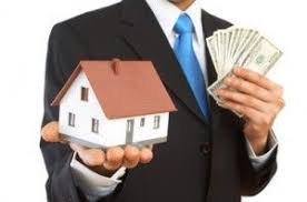 Persona mostrando una casa maqueta y dinero en su otra mano indicando la cancelación de una hipoteca